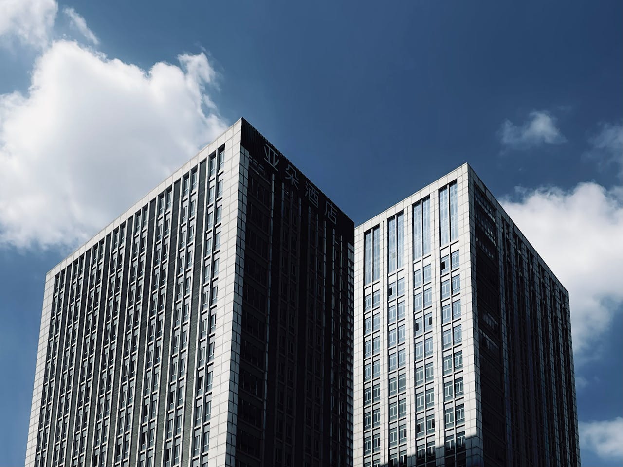 Tall skyscrapers with modern architecture reaching into a clear blue sky.